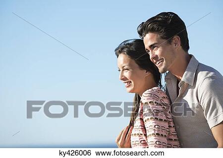 Romantic couple smiling on the beach View Large Photo Image Stock Photograph - Romantic couple smiling on the beach. Fotosearch