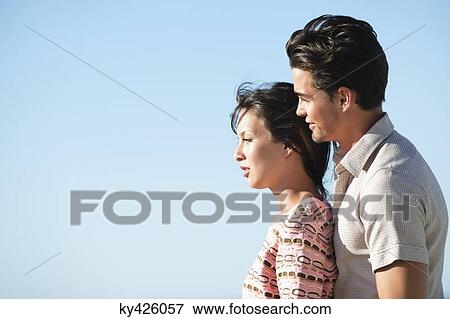 Romantic couple standing together and smiling View Large Photo Image Stock Photo - Romantic couple standing together and smiling. Fotosearch