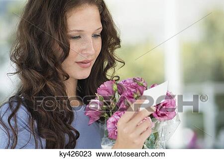 Woman reading a card with bouquet of flowers View Large Photo Image Stock Image - Woman reading a card with bouquet of flowers. Fotosearch