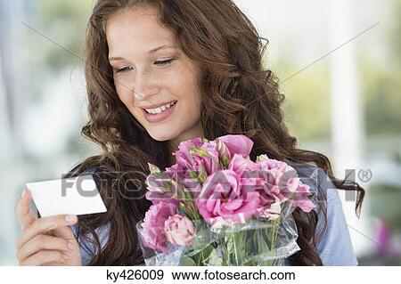Woman reading a card with bouquet of flowers View Large Photo Image Stock Photo - Woman reading a card with bouquet of flowers. Fotosearch