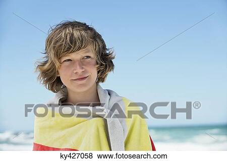 Boy wrapped in a towel on the beach View Large Photo Image Stock Photo - Boy wrapped in a towel on the beach. Fotosearch
