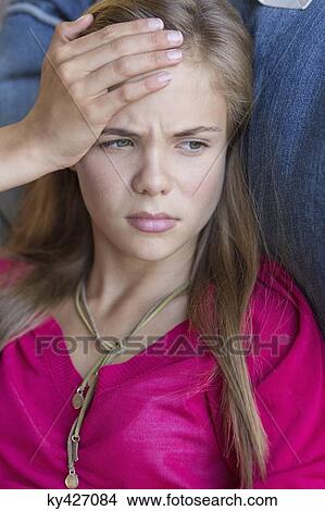 Close-up of a girl suffering from a headache View Large Photo Image Picture - Close-up of a girl suffering from a headache. Fotosearch