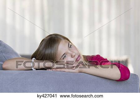 Close-up of a girl thinking on a couch View Large Photo Image Stock Image - Close-up of a girl thinking on a couch. Fotosearch