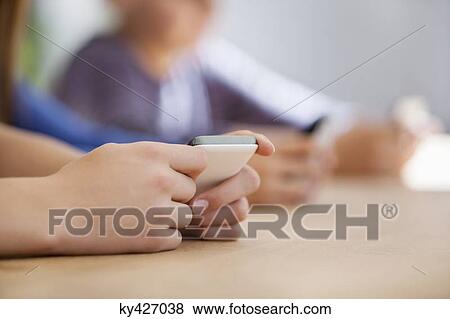 Close-up of a student using a mobile phone in a classroom View Large Photo Image Stock Photo - Close-up of a student using a mobile phone in a classroom. Fotosearch