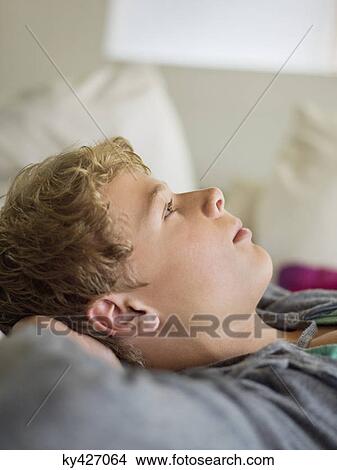 Close-up of a teenage boy lost in thoughts View Large Photo Image Picture - Close-up of a teenage boy lost in thoughts. Fotosearch