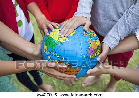 Stock Photography - Close-up of friends holding a globe. Fotosearch