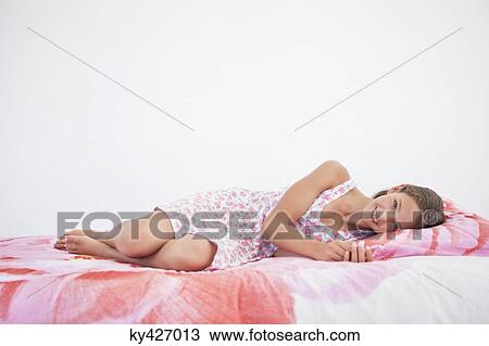 Girl lying on the bed View Large Photo Image Stock Image - Girl lying on the bed. Fotosearch