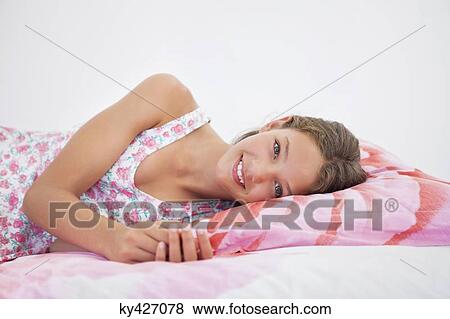 Girl lying on the bed View Large Photo Image Stock Photo - Girl lying on the bed. Fotosearch