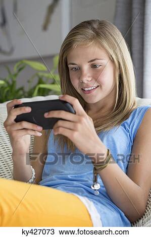 Girl playing a video game and smiling View Large Photo Image Stock Image - Girl playing a video game and smiling. Fotosearch
