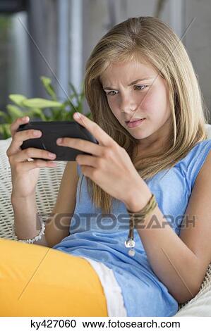 Girl playing with a video game View Large Photo Image Stock Image - Girl playing with a video game. Fotosearch
