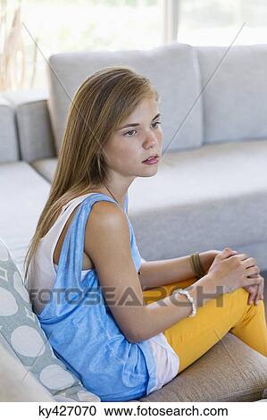 Girl sitting on a couch and looking upset View Large Photo Image Stock Image - Girl sitting on a couch and looking upset. Fotosearch