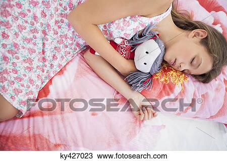 Girl sleeping on the bed with a rag doll View Large Photo Image Stock Image - Girl sleeping on the bed with a rag doll. Fotosearch