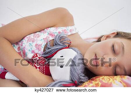 Girl sleeping on the bed with a rag doll View Large Photo Image Stock Photo - Girl sleeping on the bed with a rag doll. Fotosearch