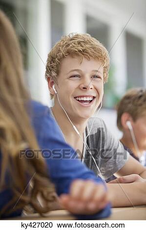 Stock Image - Students listening to music in a classroom. Fotosearch