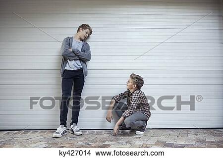 Two teenage boys looking at each other and discussing View Large Photo Image Picture - Two teenage boys looking at each other and discussing. Fotosearch