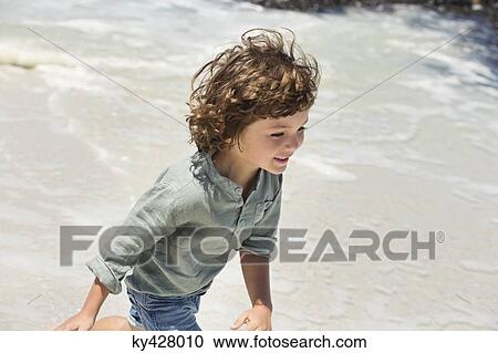 Stock Image - Boy enjoying on the beach. Fotosearch