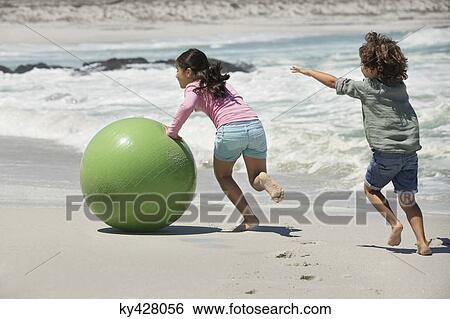 Stock Photograph - Children playing on the beach. Fotosearch