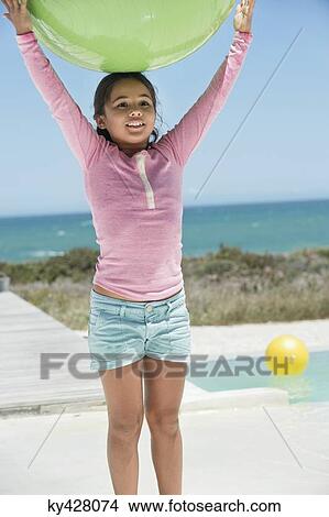Girl holding a fitness ball on the beach View Large Photo Image Picture - Girl holding a fitness ball on the beach. Fotosearch