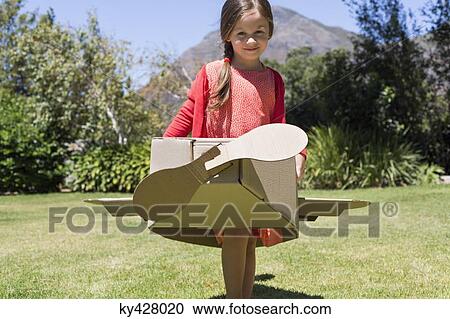 Girl playing with a cardboard airplane in lawn View Large Photo Image Stock Image - Girl playing with a cardboard airplane in lawn. Fotosearch