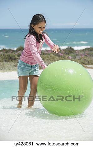 Girl playing with a fitness ball on the beach View Large Photo Image Stock Image - Girl playing with a fitness ball on the beach. Fotosearch
