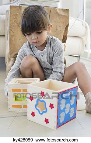 Stock Photo - Girl playing with nested cubes. Fotosearch
