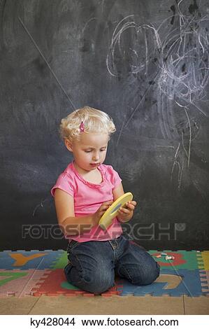 Girl playing with number puzzle in front of a black board View Large Photo Image Picture - Girl playing with number puzzle in front of a black board. Fotosearch