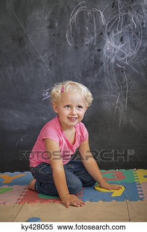 Girl playing with number puzzle in front of a black board View Large Photo Image Stock Photography - Girl playing with number puzzle in front of a black board. Fotosearch