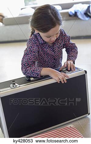 Girl trying to close a suitcase View Large Photo Image Stock Image - Girl trying to close a suitcase. Fotosearch