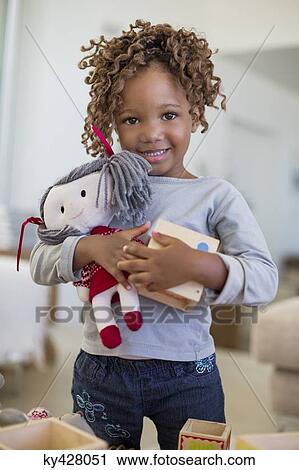 Portrait of a girl holding a rag doll View Large Photo Image Stock Image - Portrait of a girl holding a rag doll. Fotosearch