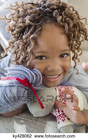 Stock Image - Portrait of a girl with a rag doll. Fotosearch