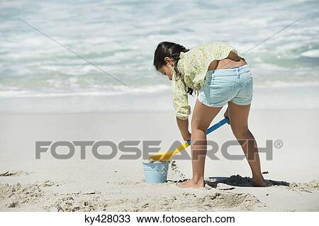 Stock Image - Rear view of a girl playing on the beach. Fotosearch