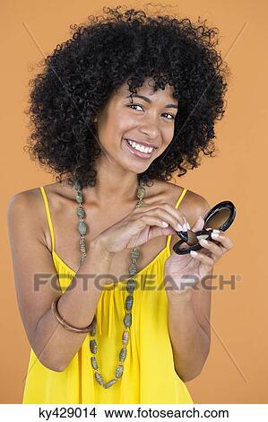 Picture - Portrait of a smiling woman doing make-up. Fotosearch