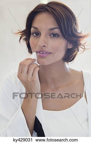 Woman applying cosmetics on her face View Large Photo Image Stock Image - Woman applying cosmetics on her face. Fotosearch
