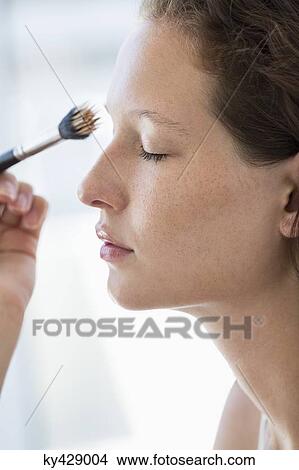 Picture - Woman brushing her eyebrow. Fotosearch