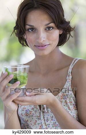 Woman holding a cup of herbal tea View Large Photo Image Stock Photo - Woman holding a cup of herbal tea. Fotosearch