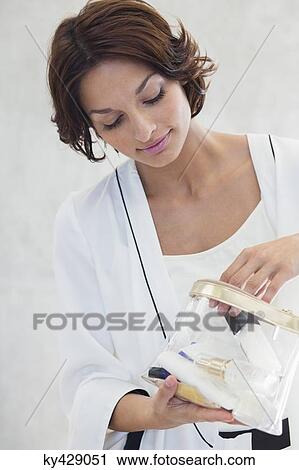 Woman looking into a makeup bag View Large Photo Image Stock Image - Woman looking into a makeup bag. Fotosearch