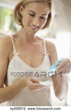 Woman pouring moisturizer on a cotton View Large Photo Image Stock Photography - Woman pouring moisturizer on a cotton. Fotosearch
