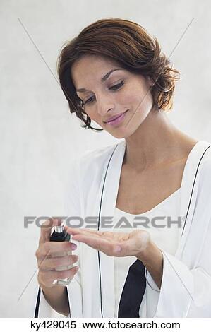 Woman spraying perfume onto her fingers View Large Photo Image Stock Photography - Woman spraying perfume onto her fingers. Fotosearch