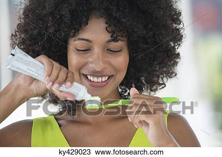 Woman squeezing out toothpaste on a toothbrush View Large Photo Image Stock Image - Woman squeezing out toothpaste on a toothbrush. Fotosearch