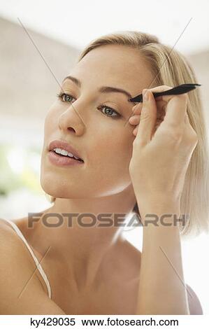 Woman tweezing her eyebrows View Large Photo Image Stock Photography - Woman tweezing her eyebrows. Fotosearch
