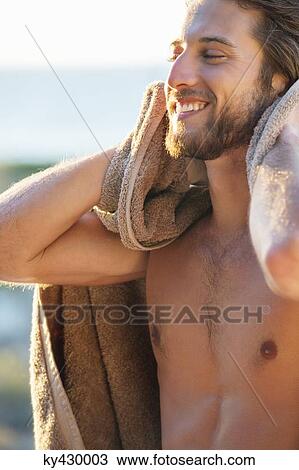Happy man wiping himself with a towel on the beach View Large Photo Image Stock Image - Happy man wiping himself with a towel on the beach. Fotosearch