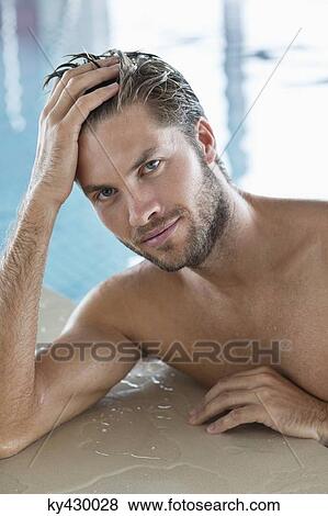 Stock Photo - Man leaning at the edge of a swimming pool. Fotosearch