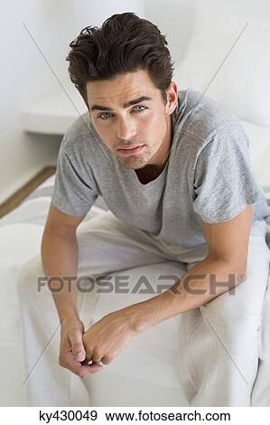 Man sitting on the bed View Large Photo Image Stock Photo - Man sitting on the bed. Fotosearch