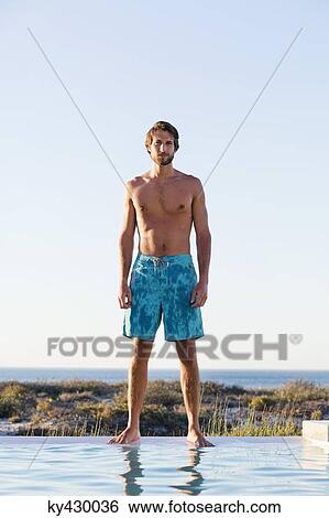 Man standing at the poolside View Large Photo Image Stock Photograph - Man standing at the poolside. Fotosearch