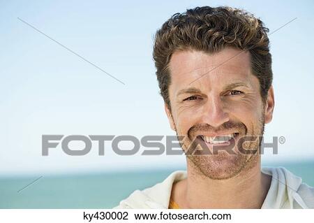 Portrait of a man smiling on the beach View Large Photo Image Stock Image - Portrait of a man smiling on the beach. Fotosearch