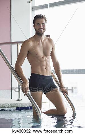Stock Image - Portrait of a man standing in a swimming pool. Fotosearch