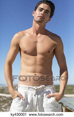 Shirtless man standing with hands in pockets View Large Photo Image Stock Image - Shirtless man standing with hands in pockets. Fotosearch