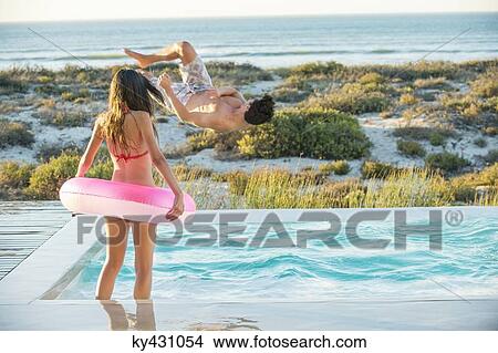Couple enjoying in a swimming pool on the beach View Large Photo Image Picture - Couple enjoying in a swimming pool on the beach. Fotosearch