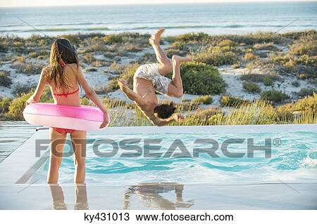 Couple enjoying in a swimming pool on the beach View Large Photo Image Stock Image - Couple enjoying in a swimming pool on the beach. Fotosearch