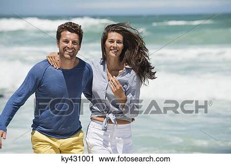 Stock Image - Couple enjoying on the beach. Fotosearch